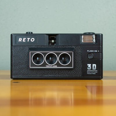 A front view of a total black Reto 3D Classic film camera. 