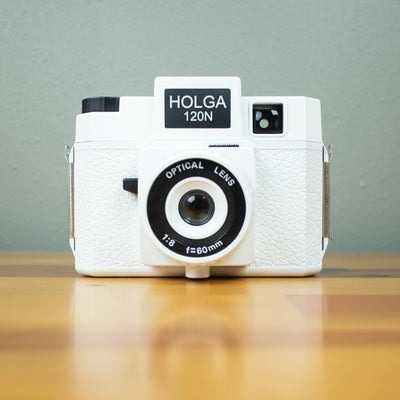 A front view of a white Holga 120N film camera with black details.