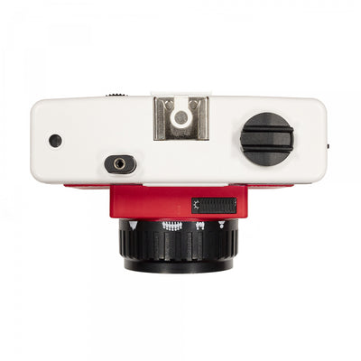 A top view of a red and white Holga 135BC 35mm film camera with black corners. 