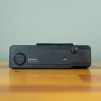 A top view of a total black Reto 3D Classic film camera. 