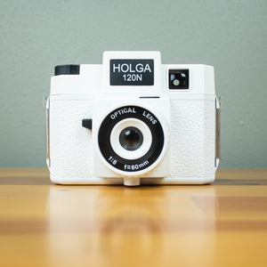 A front view of a white Holga 120N film camera with black details.