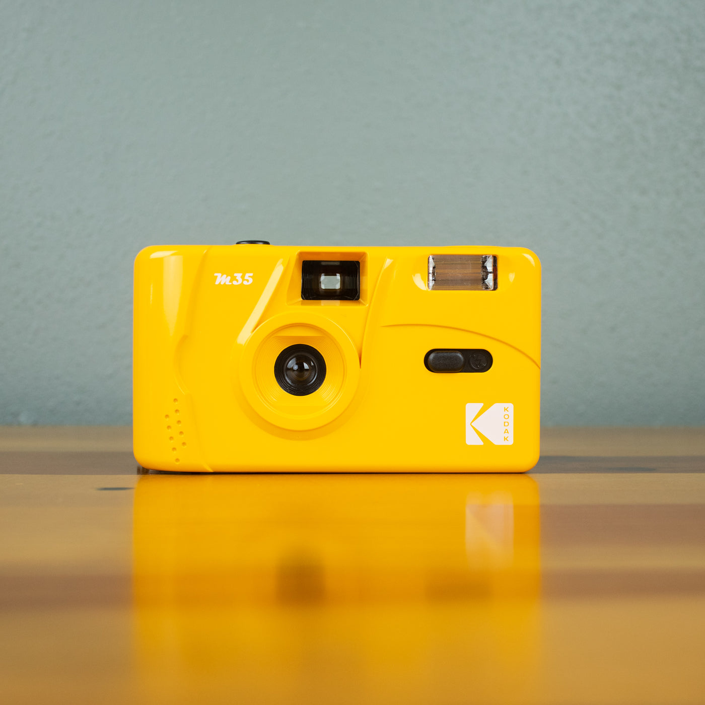 A front view of a yellow-colored Kodak M35 Film Camera.
