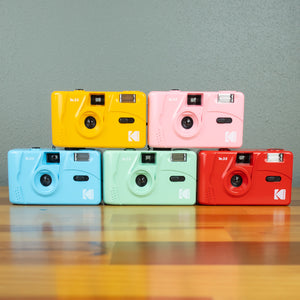 A set of 5 Kodak M35 Film Cameras in five different colors; red, pink, yellow, mint, and blue.  