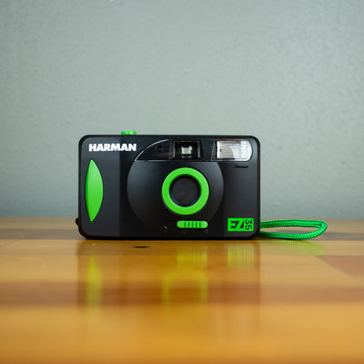 A front view of a black Harman EZ-35 Reusable 35mm film camera with green details.