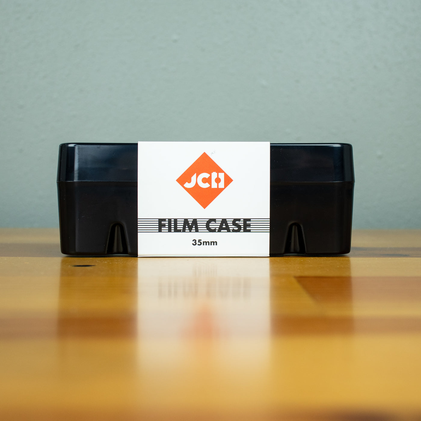 A front view of a closed black Japan Camera Hunter hard case for 35mm film.